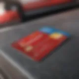 A close-up of a gas rewards credit card with a fuel pump in the background